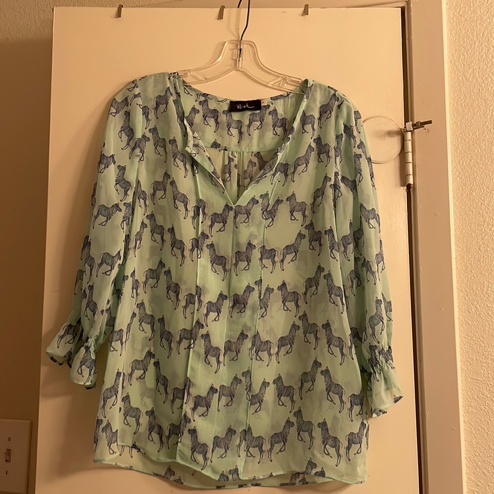 Sheer light blue top with three-quarter length sleeves and zebras printed on top